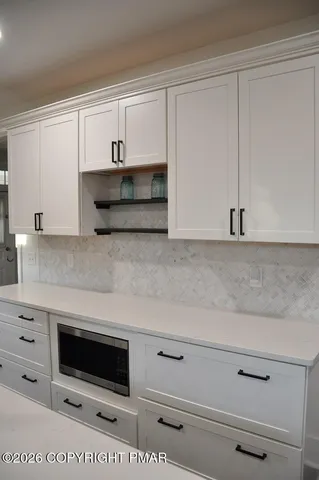 a kitchen with granite countertop white cabinets and stainless steel appliances
