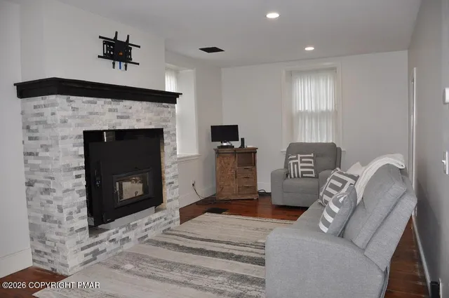 a living room with furniture a fireplace and a flat screen tv