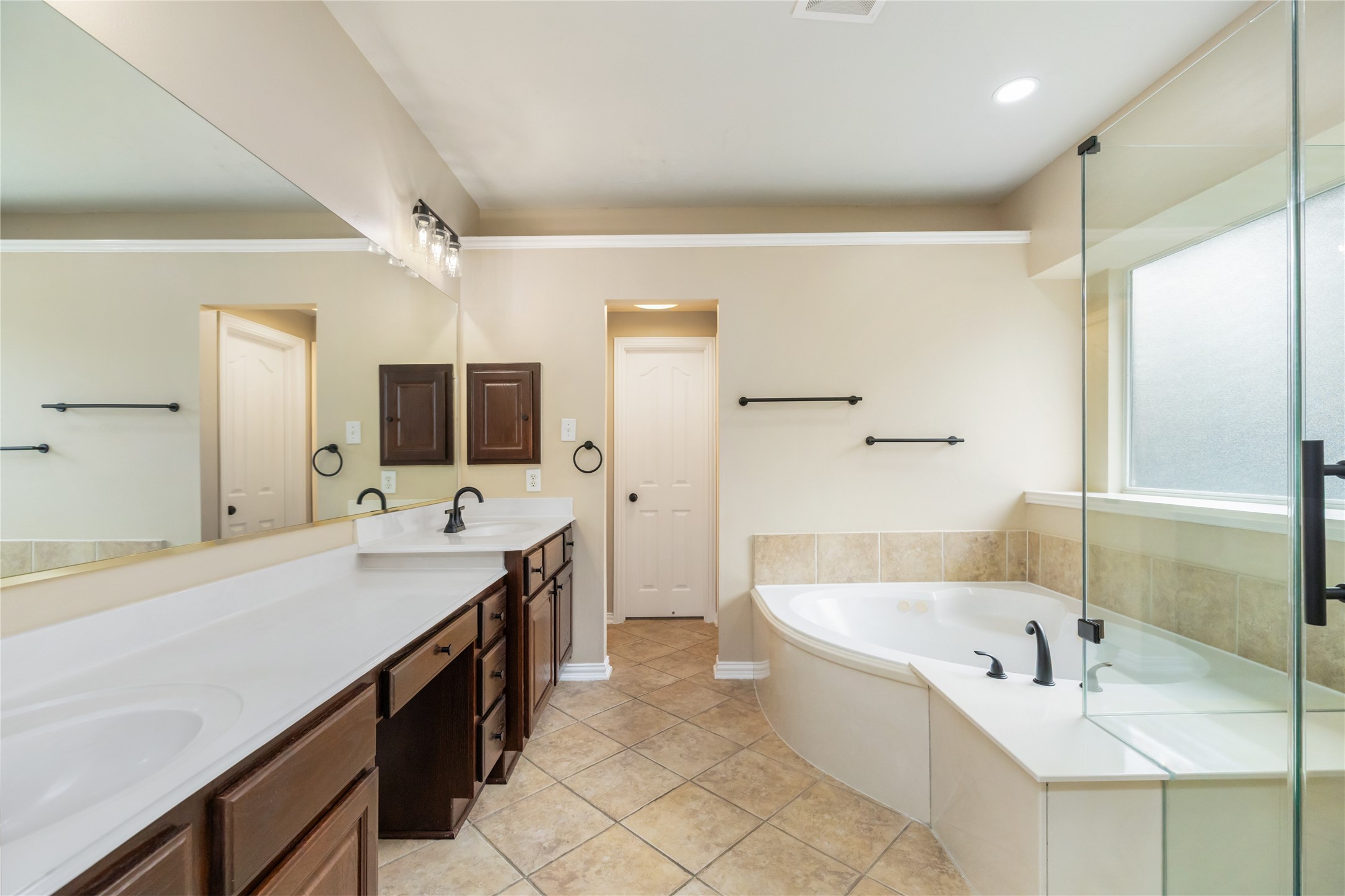 6518 Briarstone Lane Spring, TX 77379 - Photo 21 of 46 This generous bathroom features an expansive vanity with dual sinks, a luxurious soaking tub, and a glass-enclosed shower.