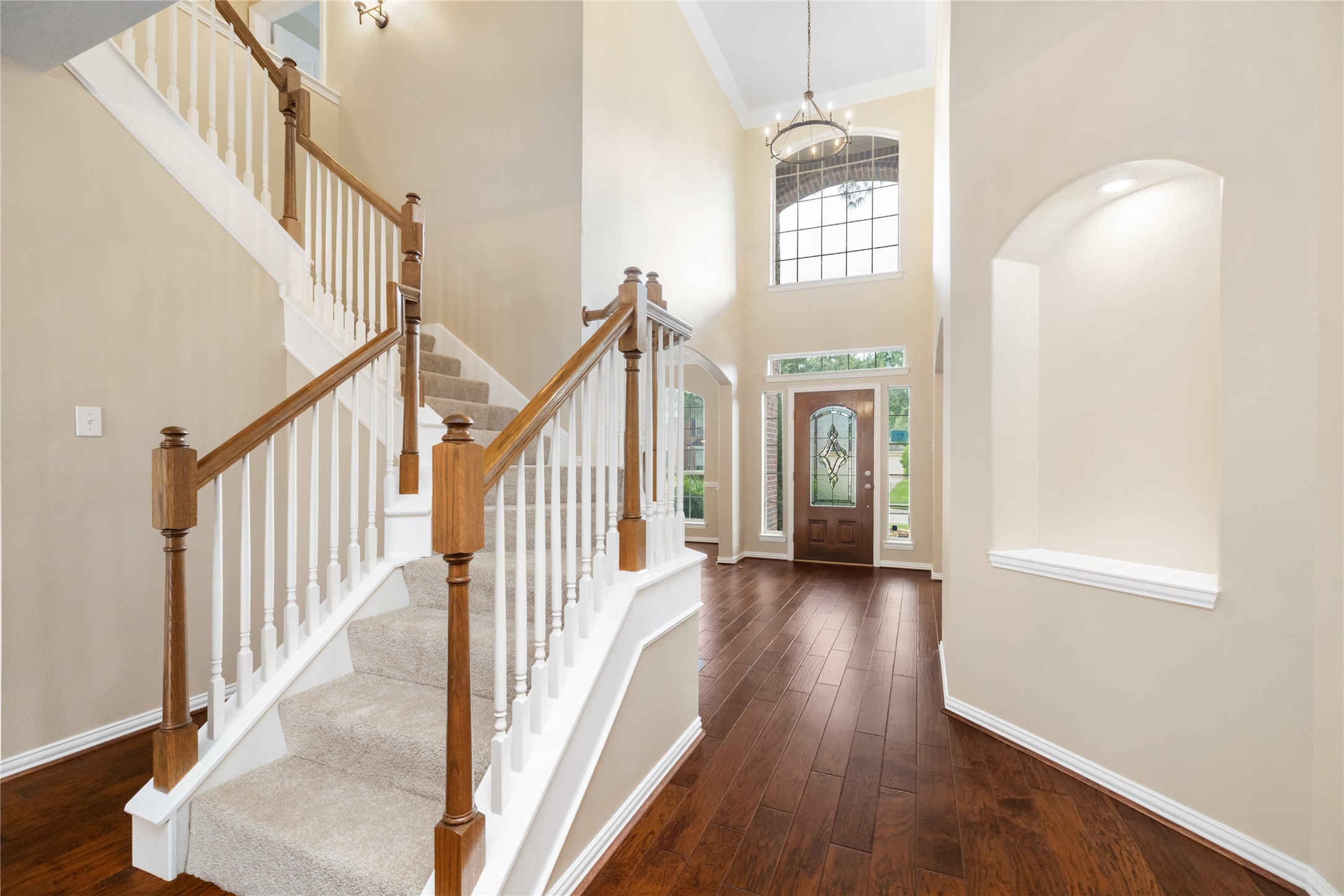 6518 Briarstone Lane Spring, TX 77379 - Photo 25 of 46 Showcasing a bright and welcoming foyer, this entry features high ceilings, a large window above the front door, and a wooden staircase with white spindles.