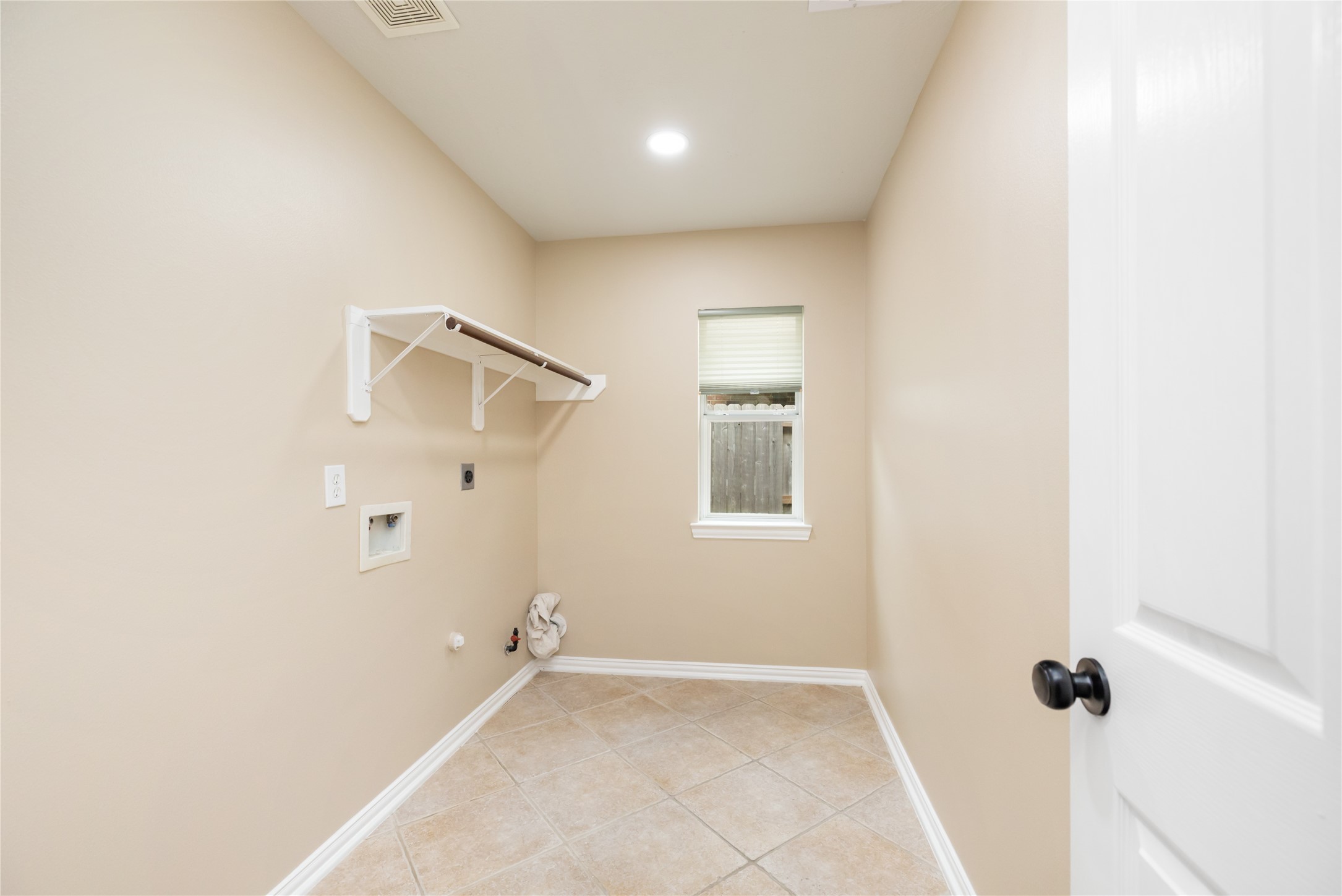 6518 Briarstone Lane Spring, TX 77379 - Photo 34 of 46 right and thoughtfully designed, the laundry room features durable tile flooring, a window that welcomes natural light, built-in shelving with a hanging rod, and convenient washer and dryer hookups—making chores easier and more organized