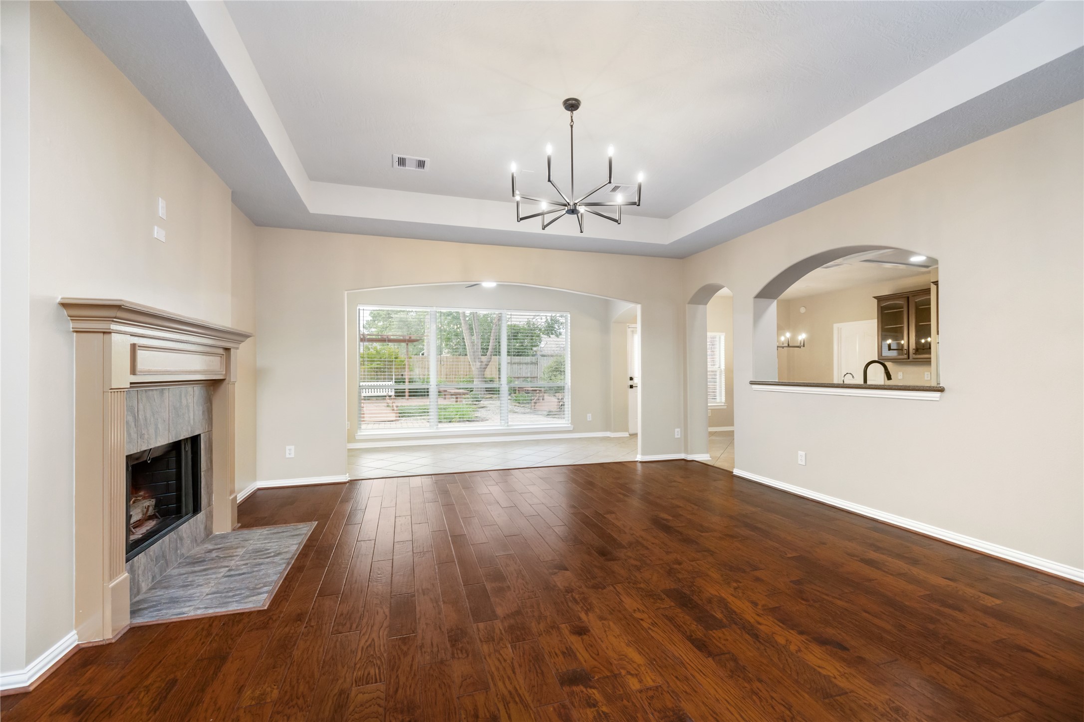 6518 Briarstone Lane Spring, TX 77379 - Photo 10 of 46 Offering a perfect blend of comfort and style, the beautiful living area features hardwood floors, a cozy fireplace, and a striking chandelier.