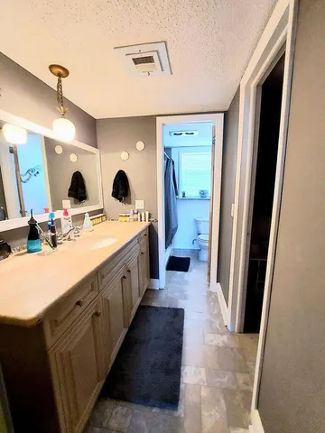 a spacious bathroom with a double vanity sink a mirror and shower