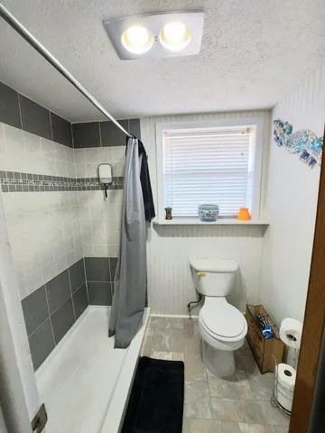 a bathroom with a toilet and a shower