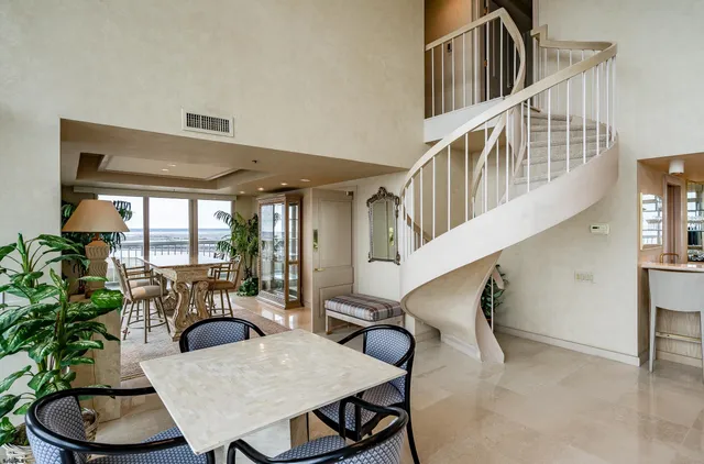 a dining room with furniture potted plants and wooden floor