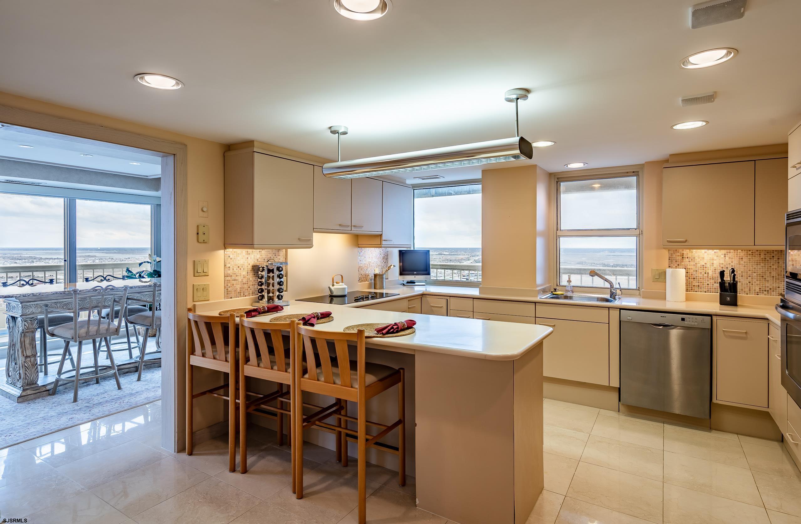 3101 Boardwalk, Unit CONDO Atlantic City, NJ 08401 - Photo 13 of 46 a kitchen with a table chairs sink and cabinets