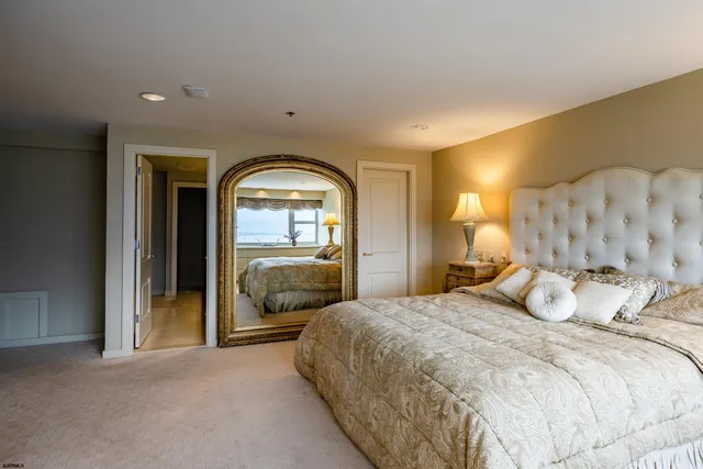 a bedroom with a large bed and a large mirror