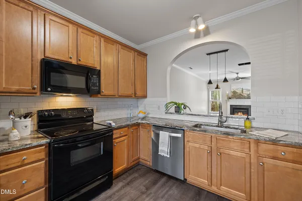a kitchen with cabinets stainless steel appliances a sink and wooden floor