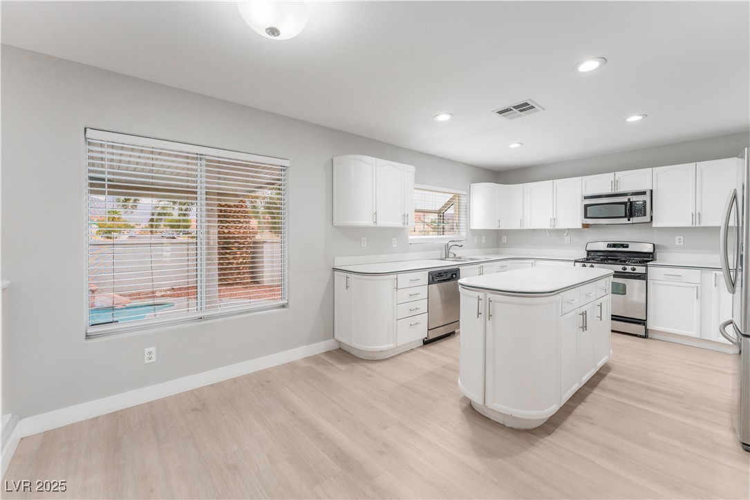 3695 Funston Way Las Vegas, NV 89129 - Photo 5 of 43 Kitchen featuring stainless steel appliances, white cabinets, light wood-style flooring, recessed lighting, and light countertops
