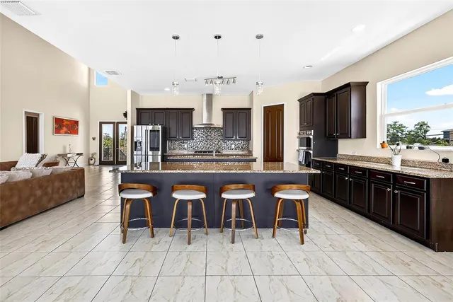 a large kitchen with kitchen island a sink table and chairs