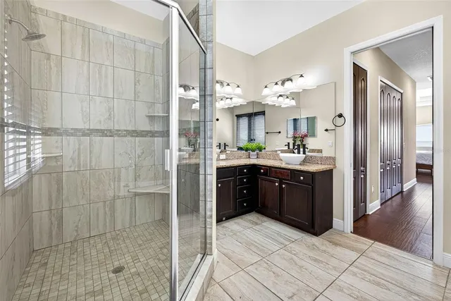a large bathroom with a double vanity sink a mirror and a shower