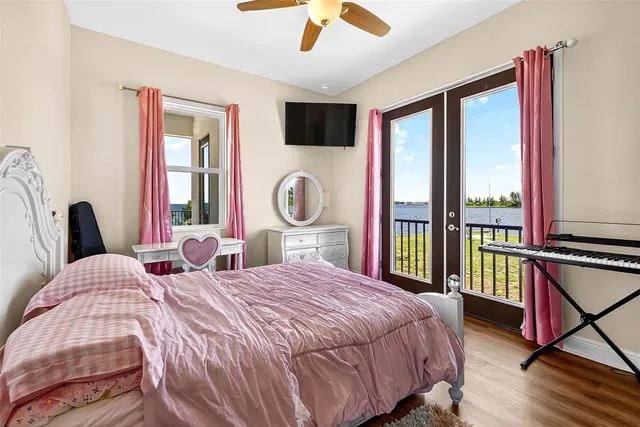 a bedroom with a bed large window and flat screen tv