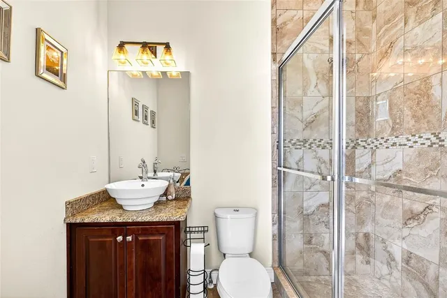 a bathroom with a granite countertop sink toilet and shower