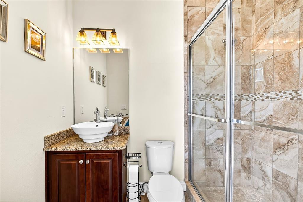 3532 West Shell Point Road Ruskin, FL 33570 - Photo 30 of 40 a bathroom with a granite countertop sink toilet and shower