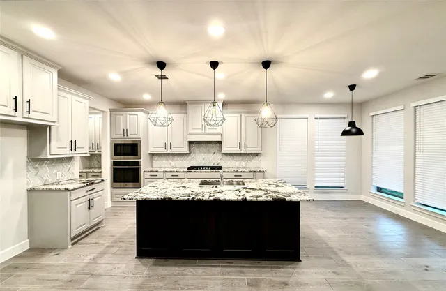 a kitchen with stainless steel appliances granite countertop a stove and a sink