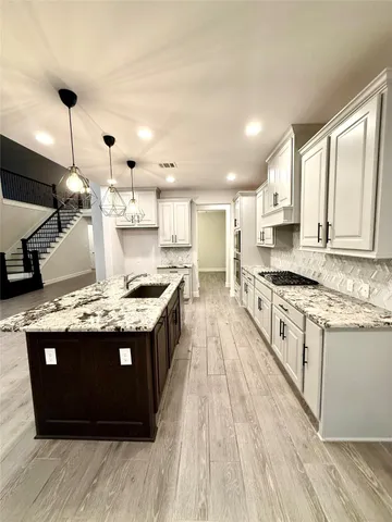 a kitchen with stainless steel appliances granite countertop a stove and a sink