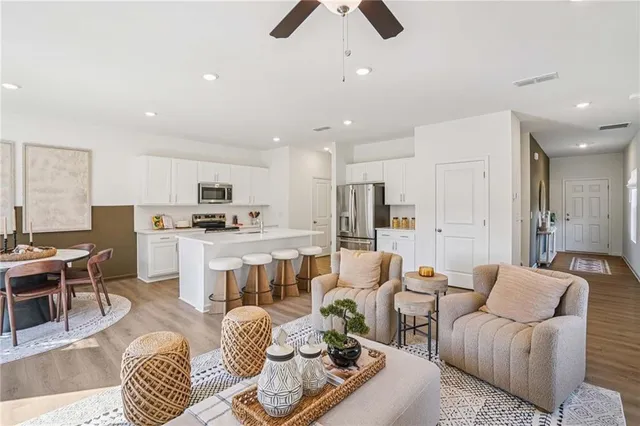 a living room with furniture kitchen view and a chandelier