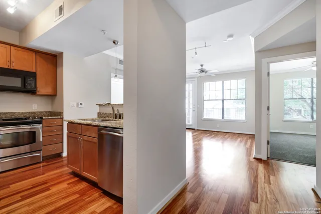a kitchen with stainless steel appliances granite countertop a stove and a wooden floors