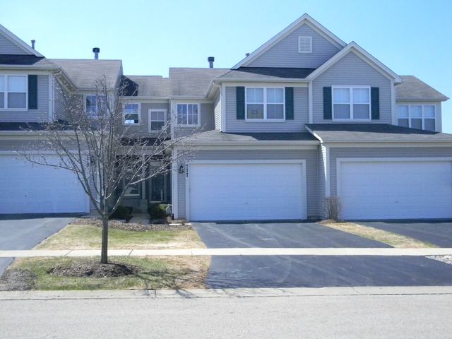 277 Grand Ridge Road, Unit 277 St. Charles, IL 60175 - Photo 2 of 13 a front view of a house with a yard and garage
