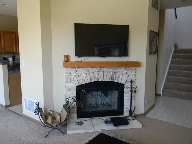 277 Grand Ridge Road, Unit 277 St. Charles, IL 60175 - Photo 5 of 13 a living room with furniture a fireplace and a flat screen tv