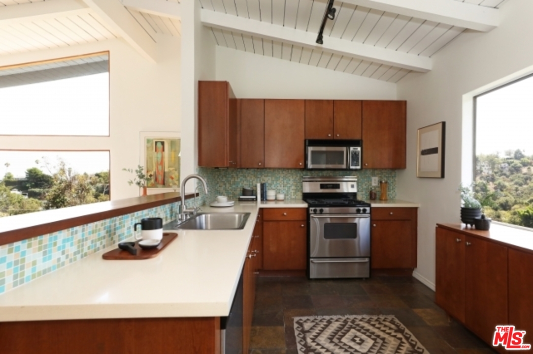 8400 Utica Drive Los Angeles, CA 90046 - Photo 7 of 32 a kitchen with stainless steel appliances a stove a sink and a microwave