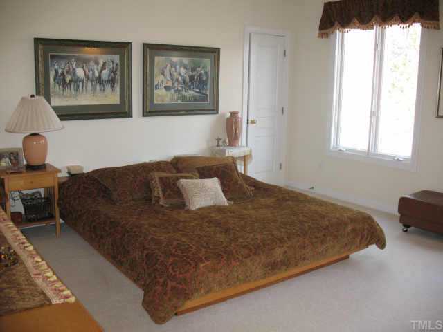 1809 Sarazen Place Raleigh, NC 27615 - Photo 7 of 9 a bed sitting in a bedroom next to a window