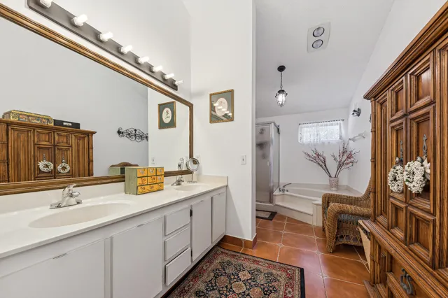 a spacious bathroom with a double vanity sink a mirror and a bathtub