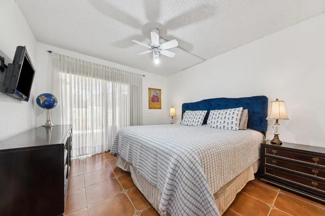 a bedroom with a bed a flat screen tv and a window