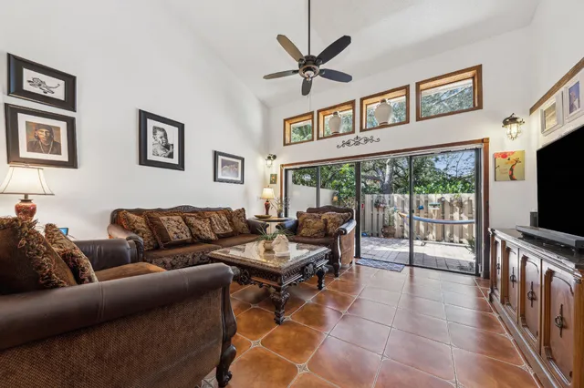 a living room with furniture a flat screen tv and a large window