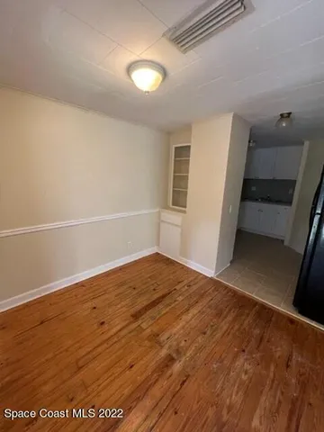 a view of empty room with wooden floor