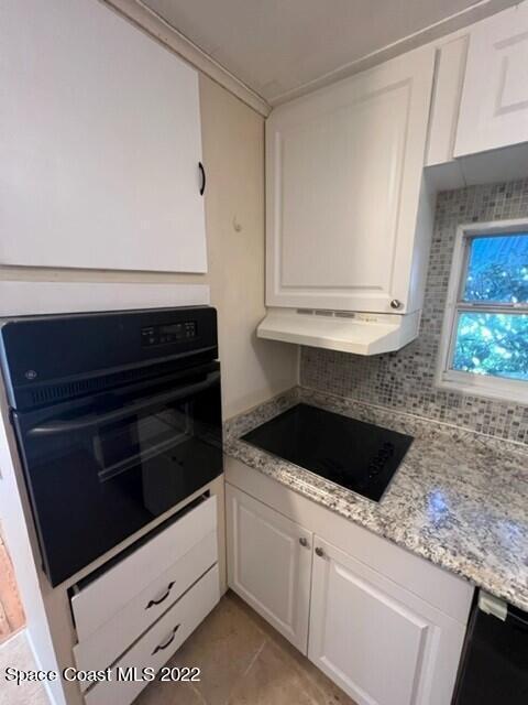 10 Olive Street Cocoa, FL 32922 - Photo 5 of 14 a kitchen with white cabinets and black appliances