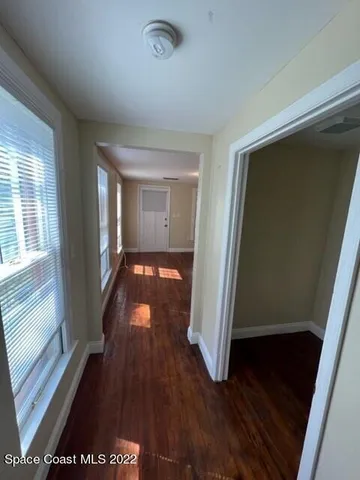a view of a hallway with wooden floor