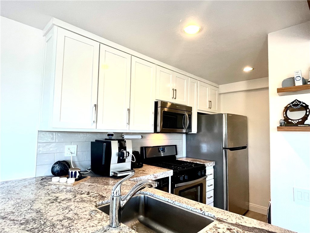 352 Y Place Laguna Beach, CA 92651 - Photo 7 of 22 a kitchen with stainless steel appliances a stove refrigerator and a microwave