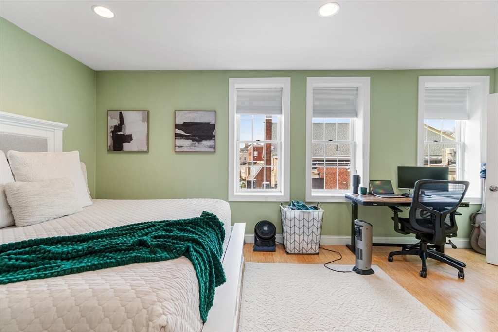 30 High Street, Unit 31 Medford, MA 02155 - Photo 22 of 27 a bedroom with a bed a table and a window