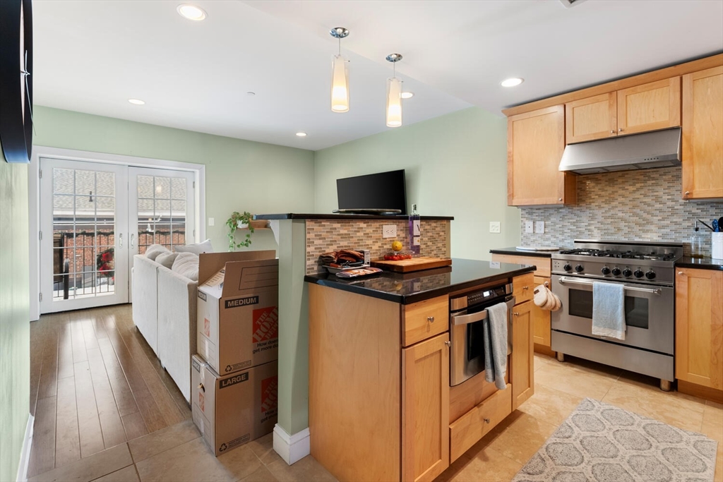 30 High Street, Unit 31 Medford, MA 02155 - Photo 6 of 27 a kitchen with stainless steel appliances granite countertop a stove and a sink