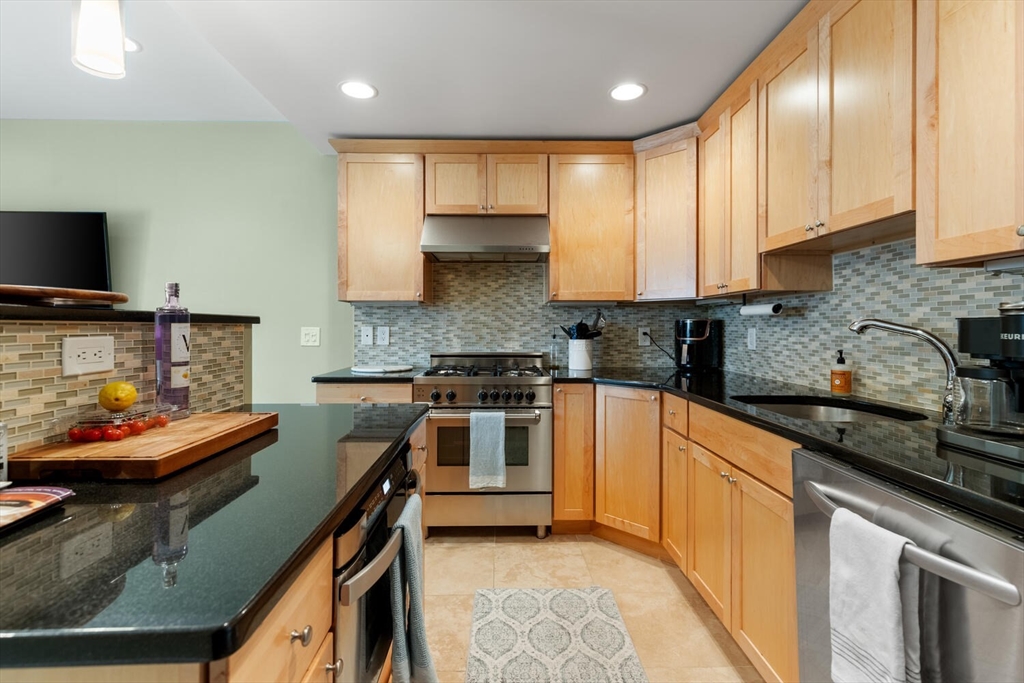 30 High Street, Unit 31 Medford, MA 02155 - Photo 7 of 27 a kitchen with stainless steel appliances granite countertop a sink stove and refrigerator
