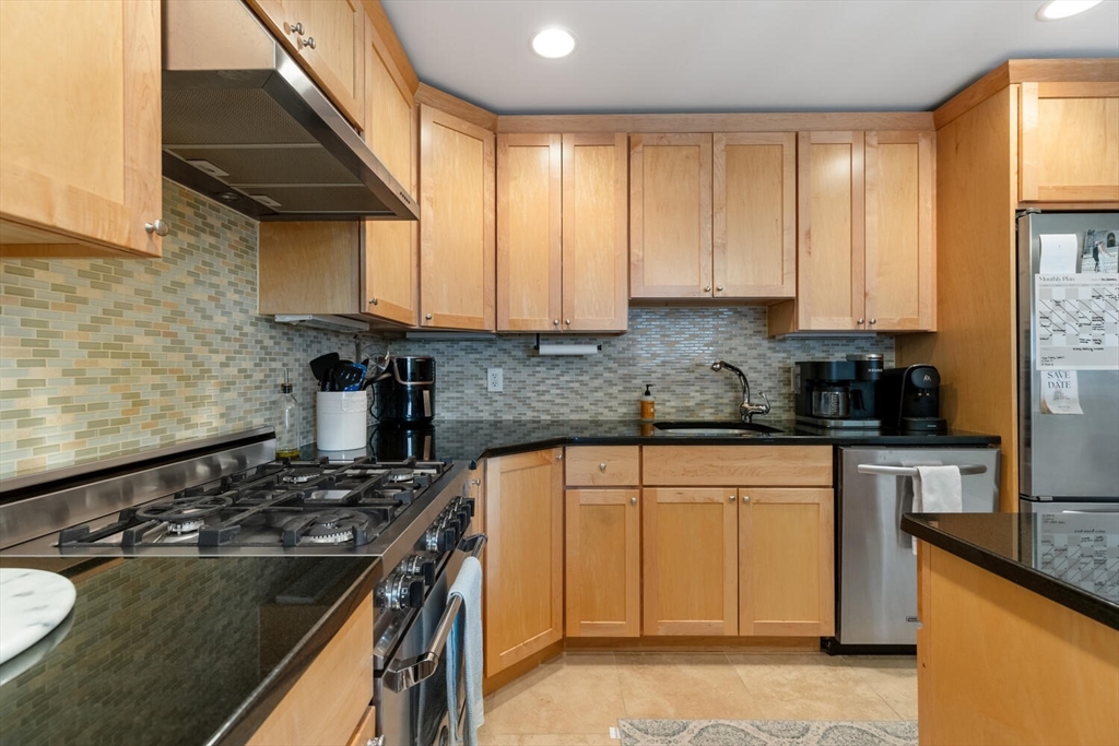30 High Street, Unit 31 Medford, MA 02155 - Photo 10 of 27 a kitchen with granite countertop a sink stove and cabinets