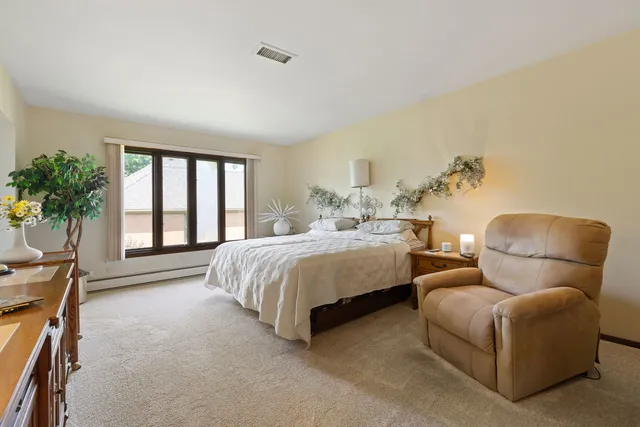 a bedroom with bed and a potted plant