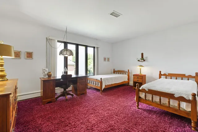 a bedroom with furniture and a large window