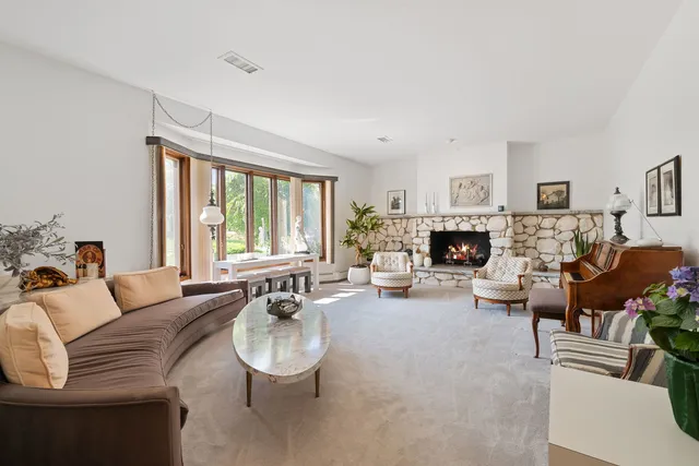 a living room with furniture a fireplace and a large window