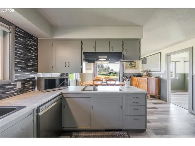 a kitchen with kitchen island a sink stainless steel appliances and cabinets