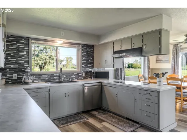 a kitchen with granite countertop a sink window and cabinets