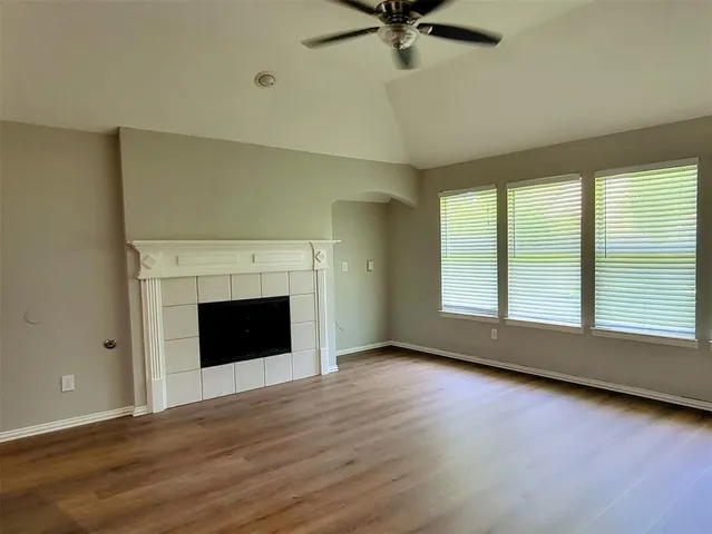 a view of an empty room with a window and fireplace