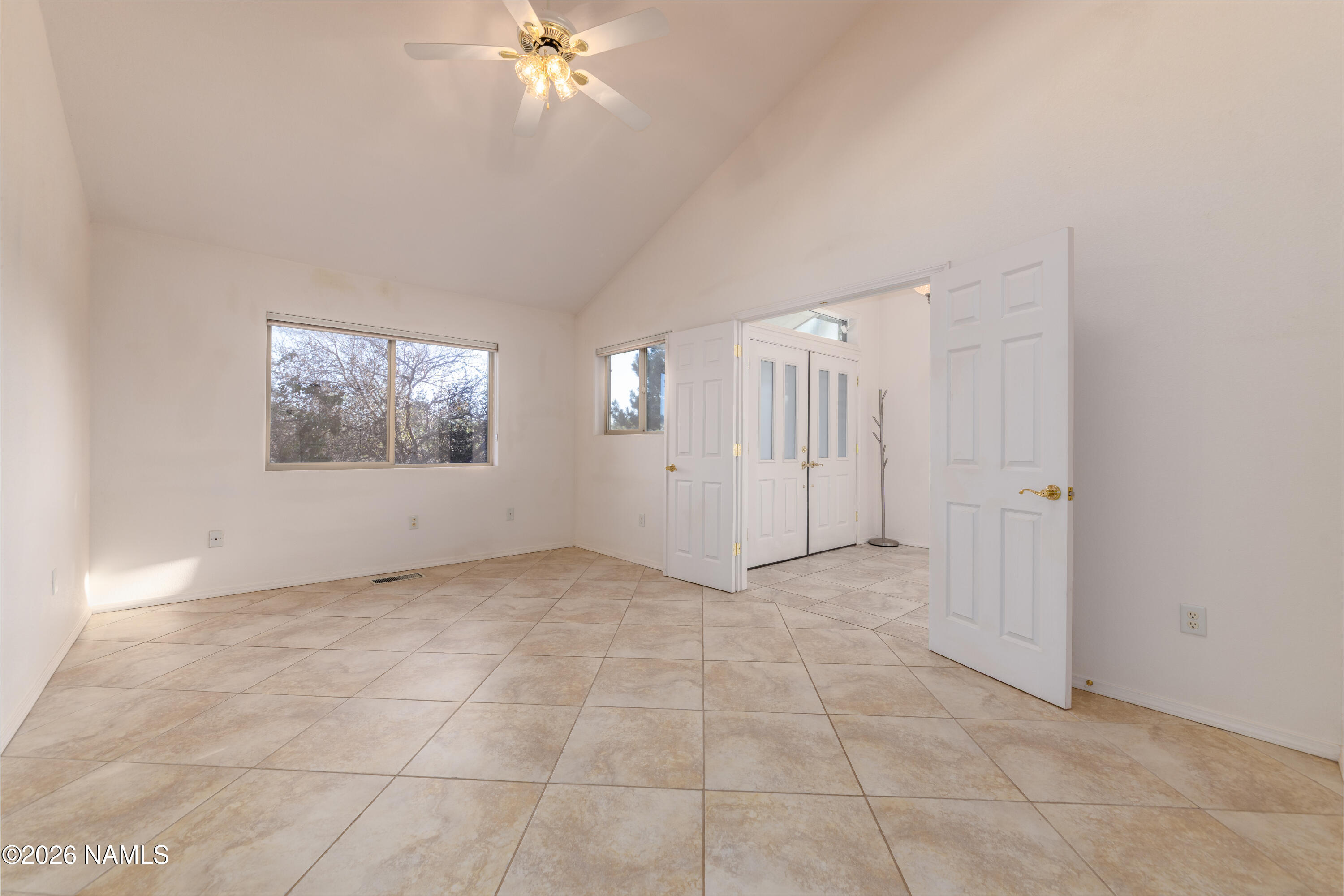 6875 Will O' Pete Road Flagstaff, AZ 86004 - Photo 12 of 43 an empty room with a chandelier fan and windows