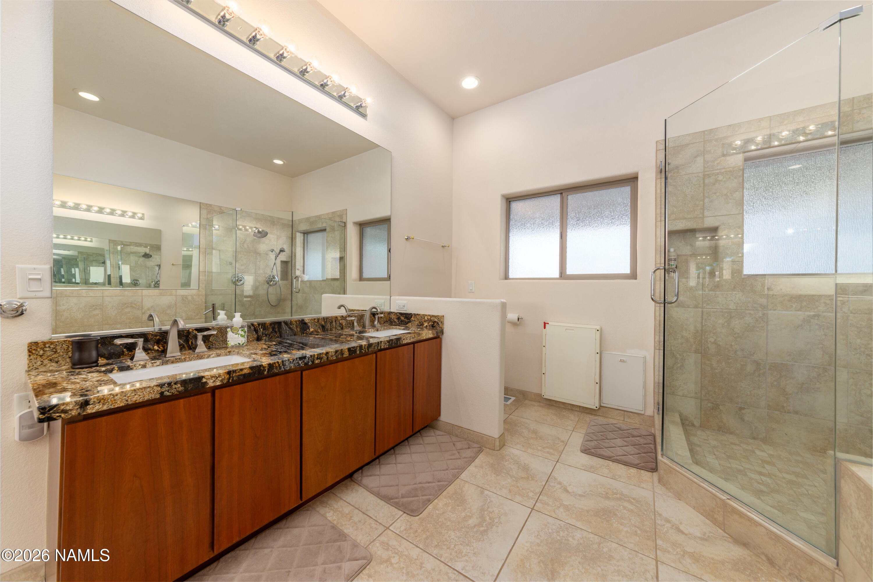 6875 Will O' Pete Road Flagstaff, AZ 86004 - Photo 26 of 43 a large bathroom with a granite countertop sink a mirror and a shower