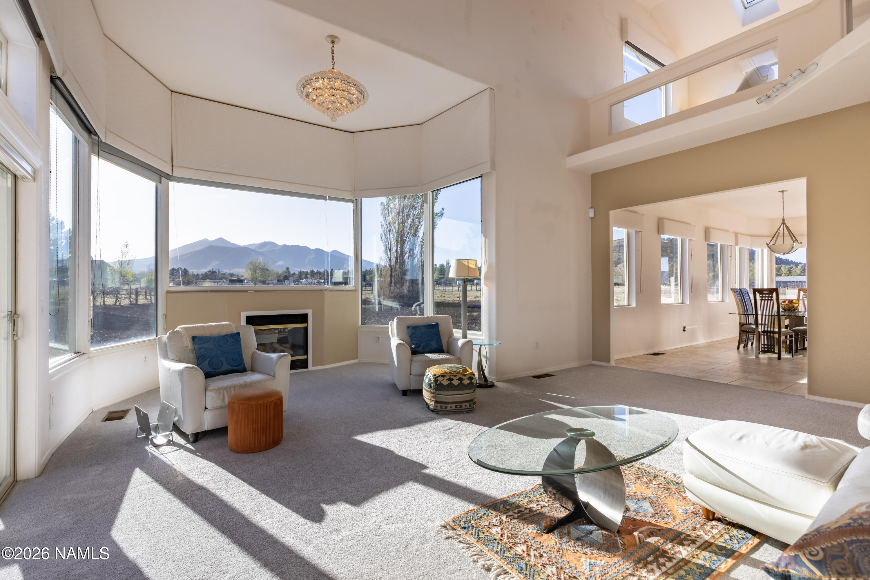 6875 Will O' Pete Road Flagstaff, AZ 86004 - Photo 7 of 43 a living room with furniture a fireplace and a floor to ceiling window
