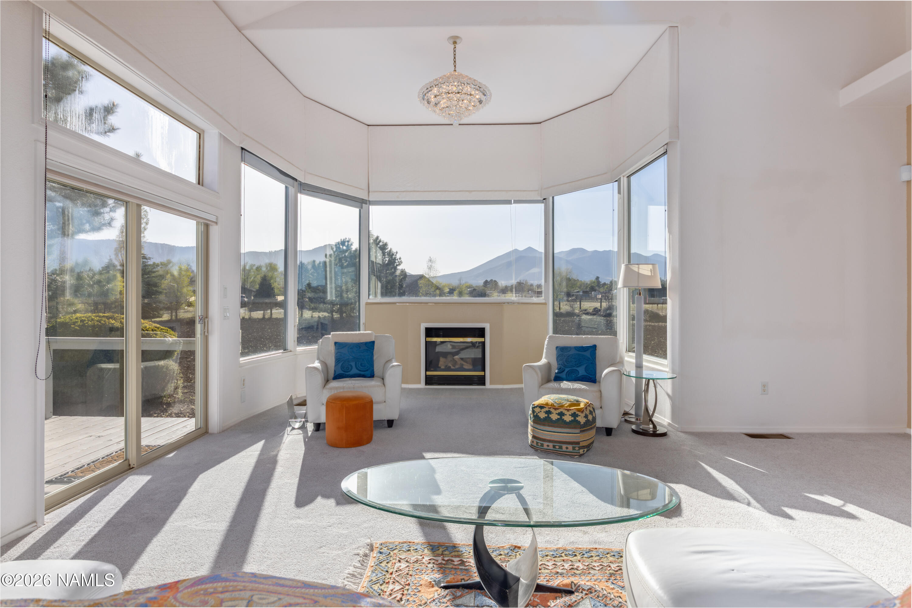 6875 Will O' Pete Road Flagstaff, AZ 86004 - Photo 9 of 43 a living room with furniture a fireplace and a large window