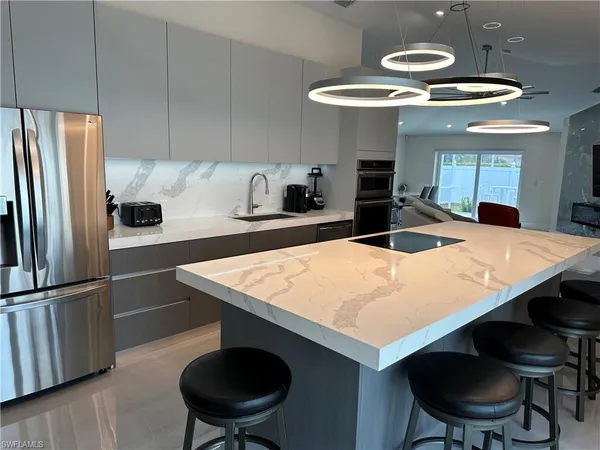 a kitchen with stainless steel appliances a table chairs and microwave