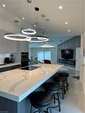 a kitchen with stainless steel appliances a table chairs and a refrigerator
