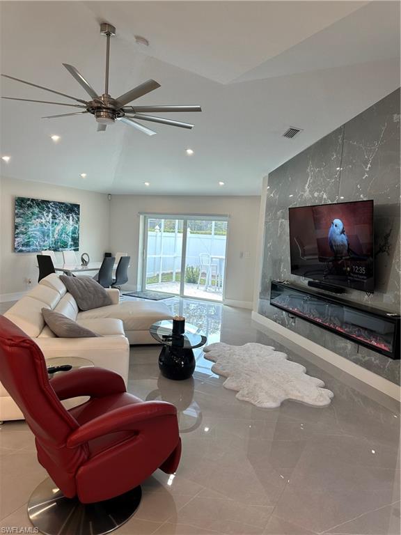 1595 Whispering Oaks Circle Naples, FL 34110 - Photo 7 of 15 a living room with furniture a window and a flat screen tv